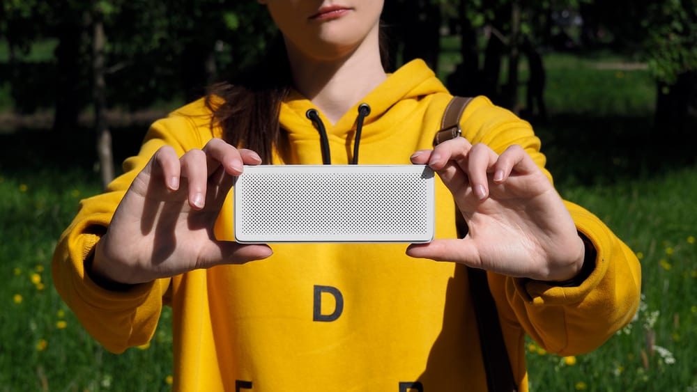 Bluetooth speaker in girls hand with nature